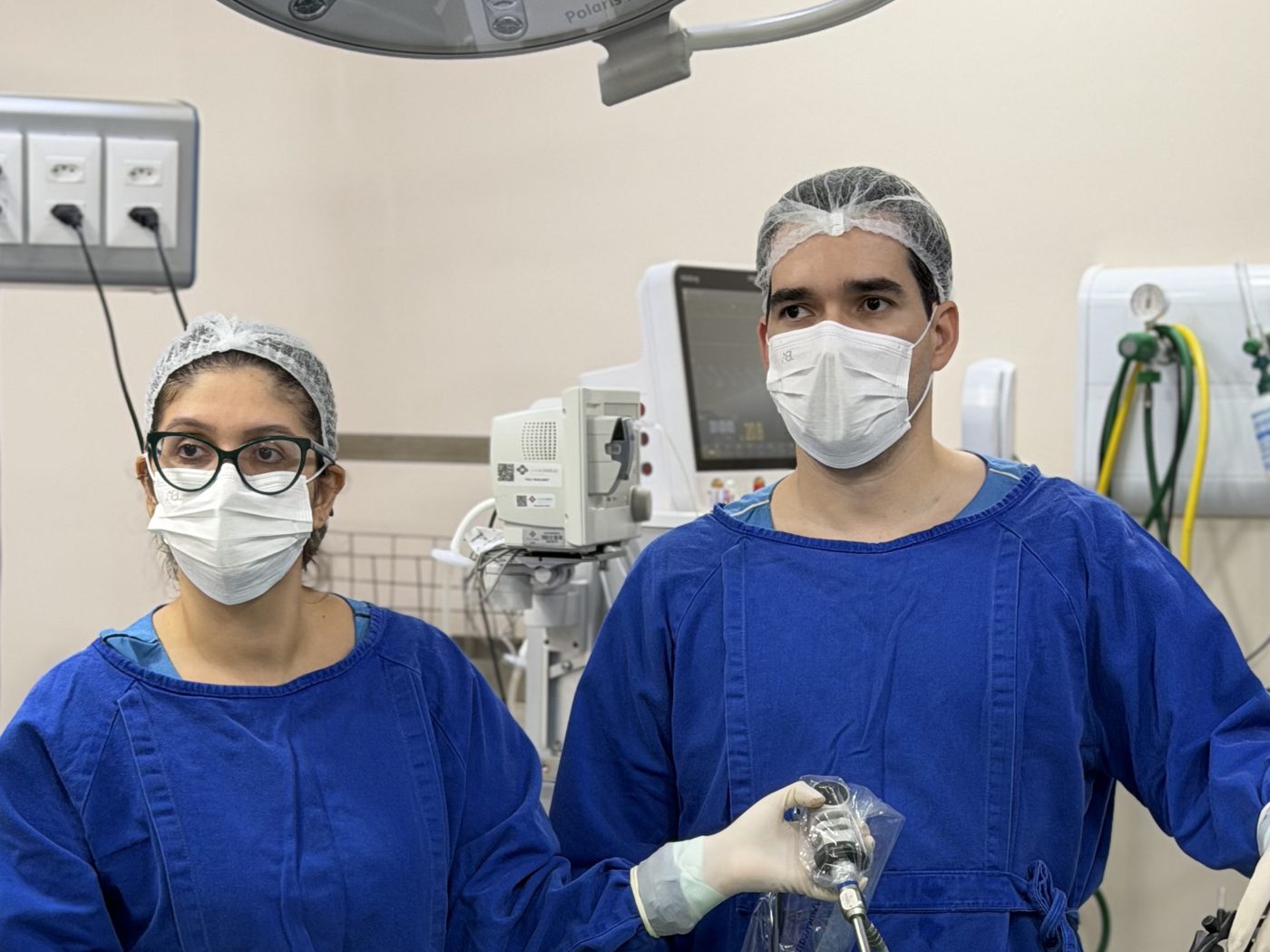 Dr. Eduardo Medeiros e cirurgiã auxiliar no centro cirúrgico, durante cirurgia por vídeo